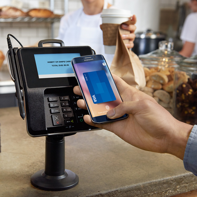 Using Samsung Pay on mobile device at coffee shop.